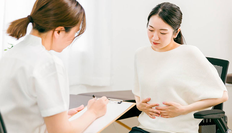 お腹の不調を訴える女性の患者